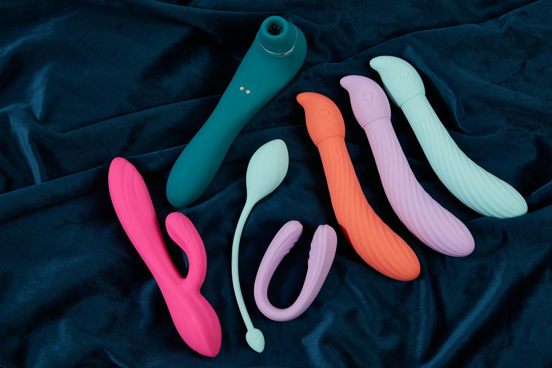 Yellow silicone lemon vibrator surrounded by fresh fruit on a bright background