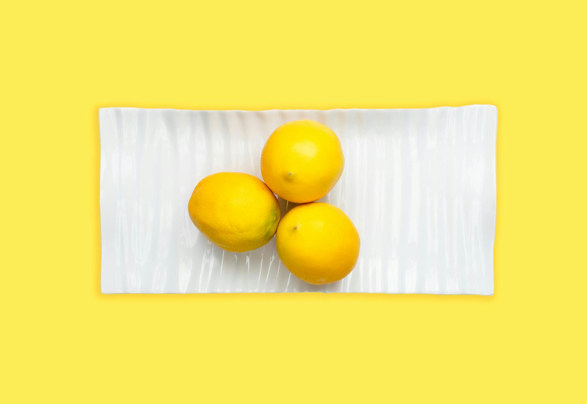 Bright ripe lemons with pleasant aroma arranged on a pastel background, conveying freshness and natural vitality.