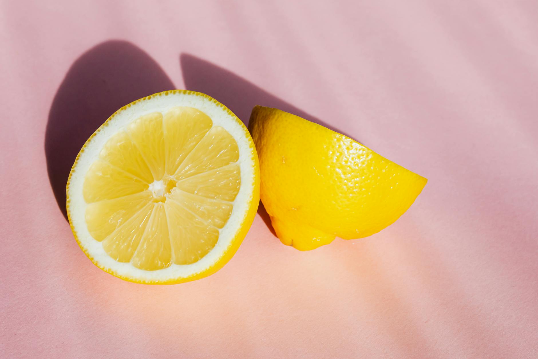 Fresh bright yellow lemons arranged on a pastel green background